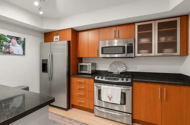 a kitchen with stainless steel appliances granite countertop a stove a refrigerator and a microwave