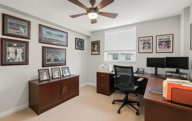 a view of a workspace with furniture and a window