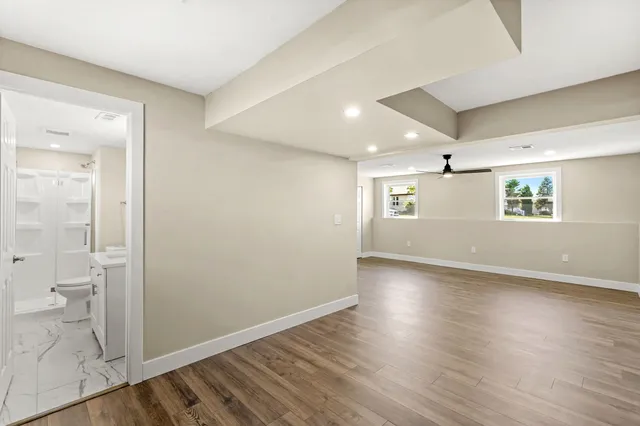 an empty room with wooden floor and a bathroom
