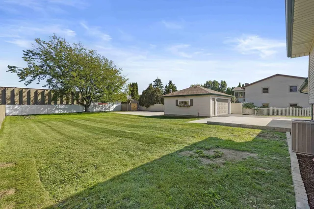 a swimming pool is sitting in the grass with large trees