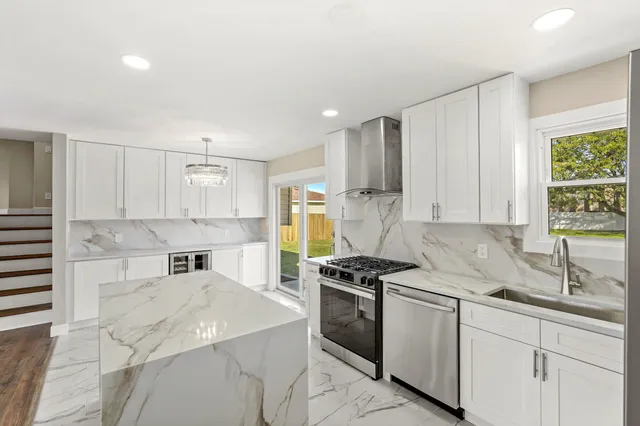 a kitchen with stainless steel appliances kitchen island granite countertop a sink stove and cabinets