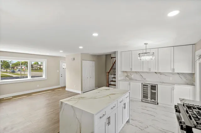 a spacious bathroom with a granite countertop sink a mirror and a bathtub