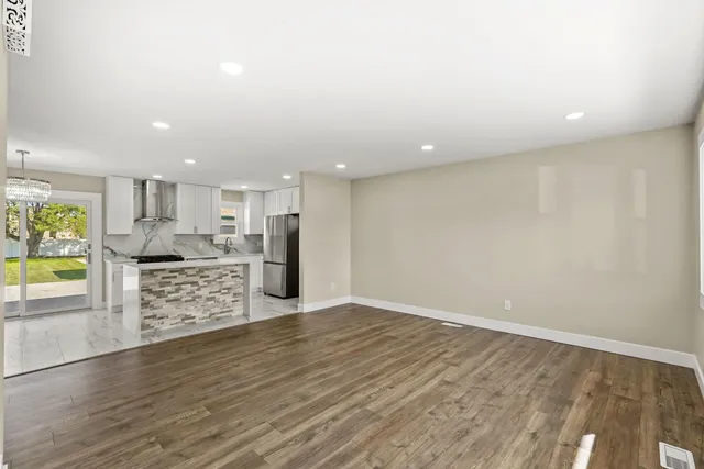 a view of kitchen with wooden floor and electronic appliances