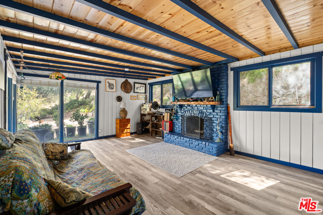 9738 Commerce Avenue Tujunga, CA 91042 - Photo 3 of 17 a living room with furniture a fireplace and a floor to ceiling window