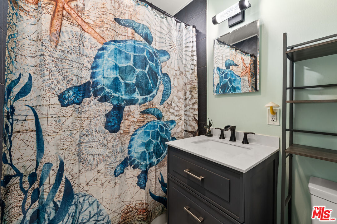 9738 Commerce Avenue Tujunga, CA 91042 - Photo 6 of 17 a bathroom with a sink mirror and vanity