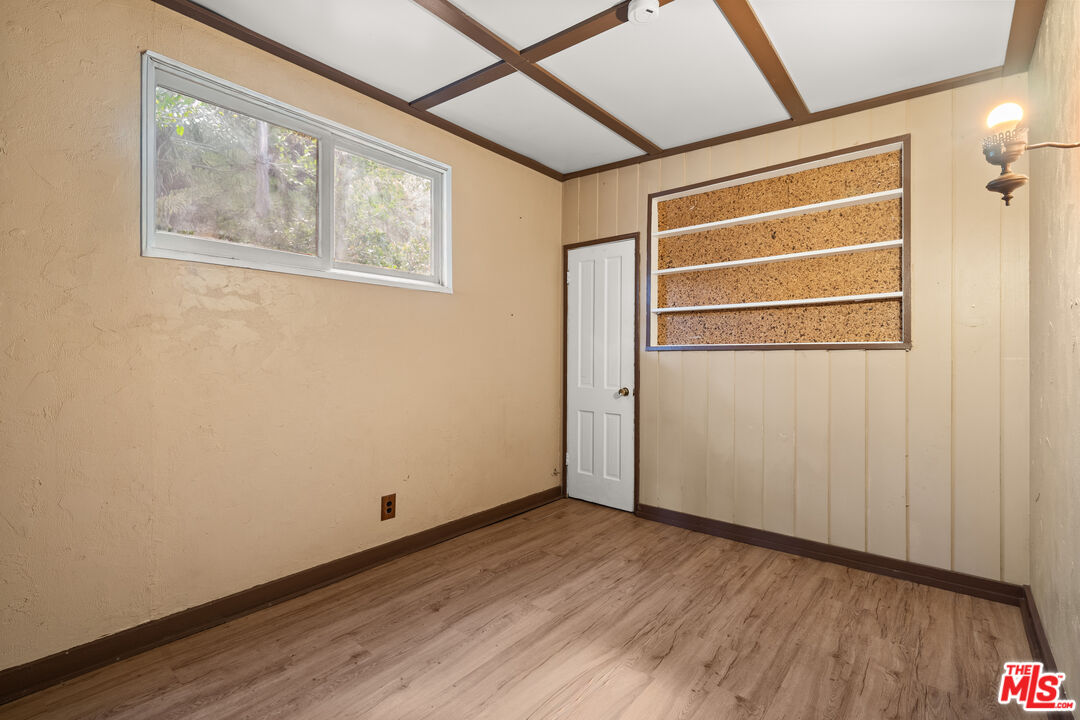 9738 Commerce Avenue Tujunga, CA 91042 - Photo 7 of 17 a view of an empty room with wooden floor and a window