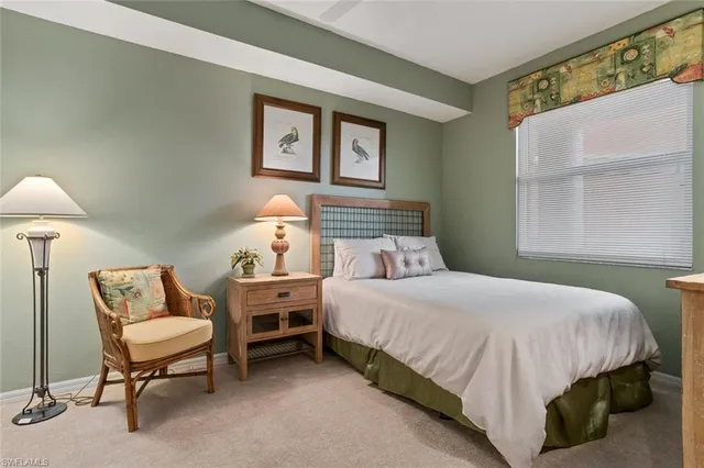 a bedroom with a bed a lamp and a window