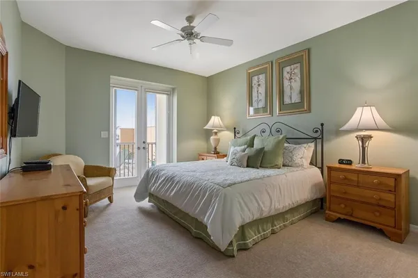 a bedroom with a bed a couch and a chandelier