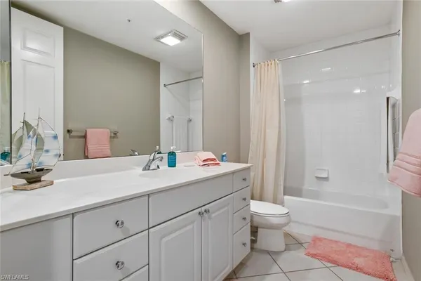 a bathroom with a double vanity sink toilet mirror and bathtub