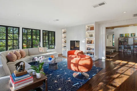 a living room with furniture fireplace and a large window