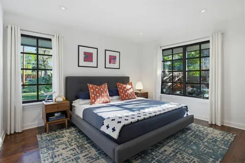 a bed sitting in a bedroom next to a window