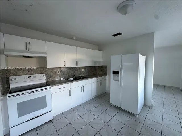 a kitchen with white cabinets and white appliances