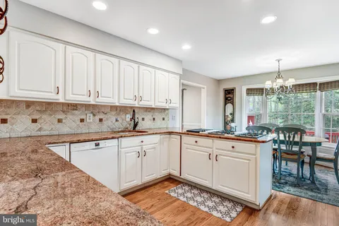 a kitchen with granite countertop white cabinets and white appliances