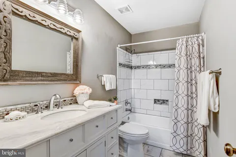 a bathroom with a granite countertop toilet sink and mirror