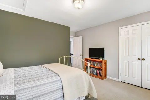 a bedroom with a bed a bookshelf and a window