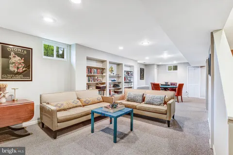a living room with furniture a rug and a bookshelf