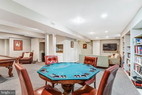 a room with furniture pool table and wooden floor