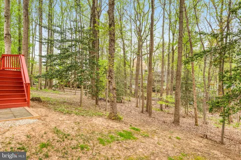 a view of a backyard with table and chairs under an umbrella with wooden fence