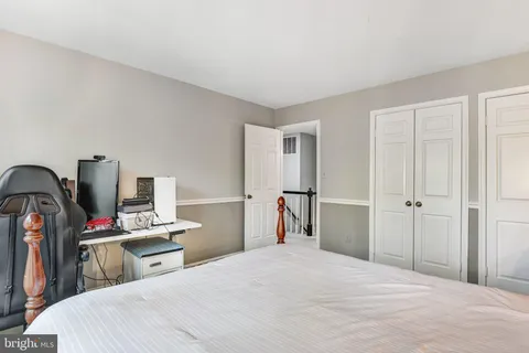 a bedroom with a bed and a wooden floor