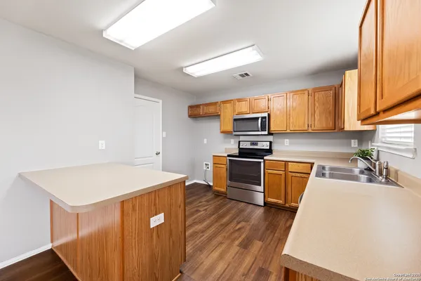 a large kitchen with stainless steel appliances granite countertop a stove a sink dishwasher and a refrigerator