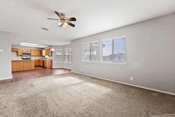 a large kitchen with cabinets wooden floor and stainless steel appliances
