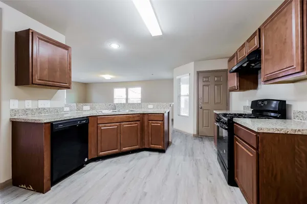a kitchen with a sink stove top oven and cabinets
