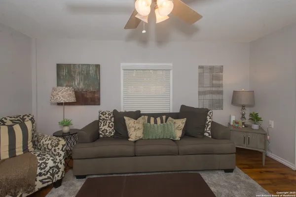 a living room with furniture and a ceiling fan