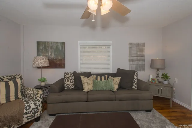 a living room with furniture and a ceiling fan