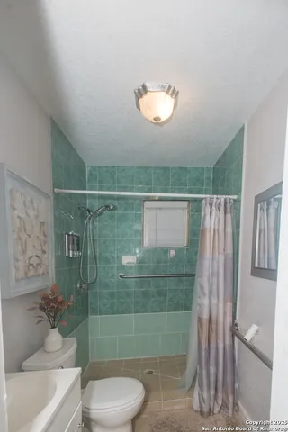 a bathroom with a toilet sink and mirror
