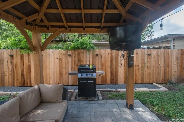 a view of patio with table and chairs potted plants with wooden fence
