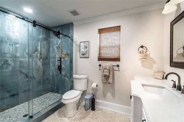 a bathroom with a granite countertop toilet a sink a shower and a mirror