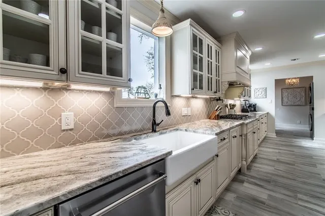 a large kitchen with granite countertop a sink and a stove