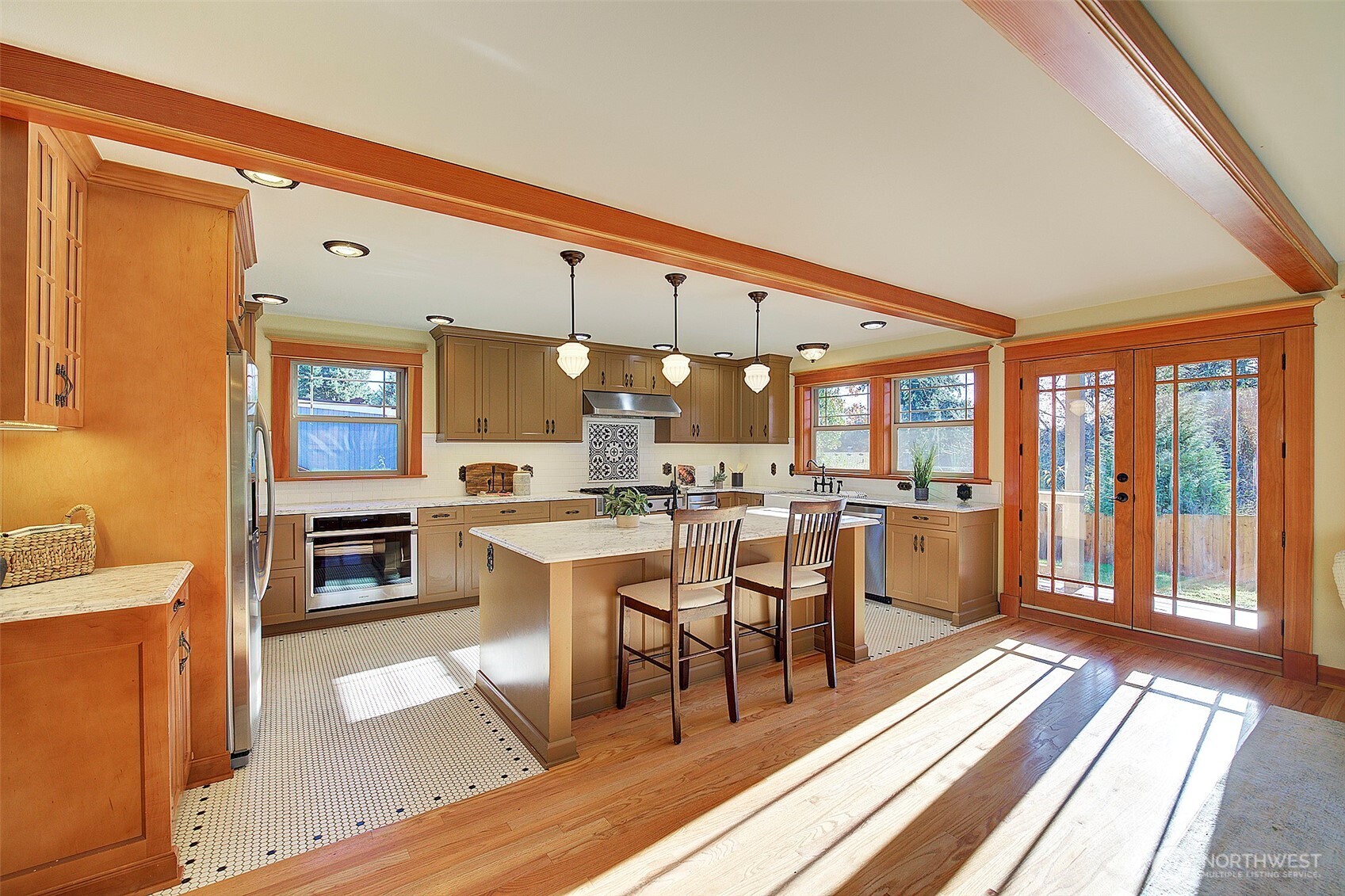 311 Northeast 117th Street Seattle, WA 98125 - Photo 7 of 40 a dining hall with stainless steel appliances granite countertop a stove top oven a dining table and chairs with wooden floor