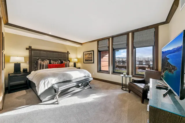 a bed sitting in a spacious bedroom next to a window