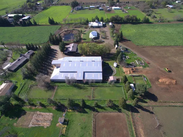 an aerial view of a house with a yard and lake view in back yard