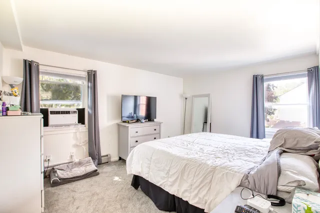 a bedroom with a bed a flat screen tv and dresser