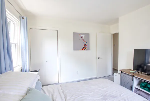 a bedroom with a bed and a flat screen tv