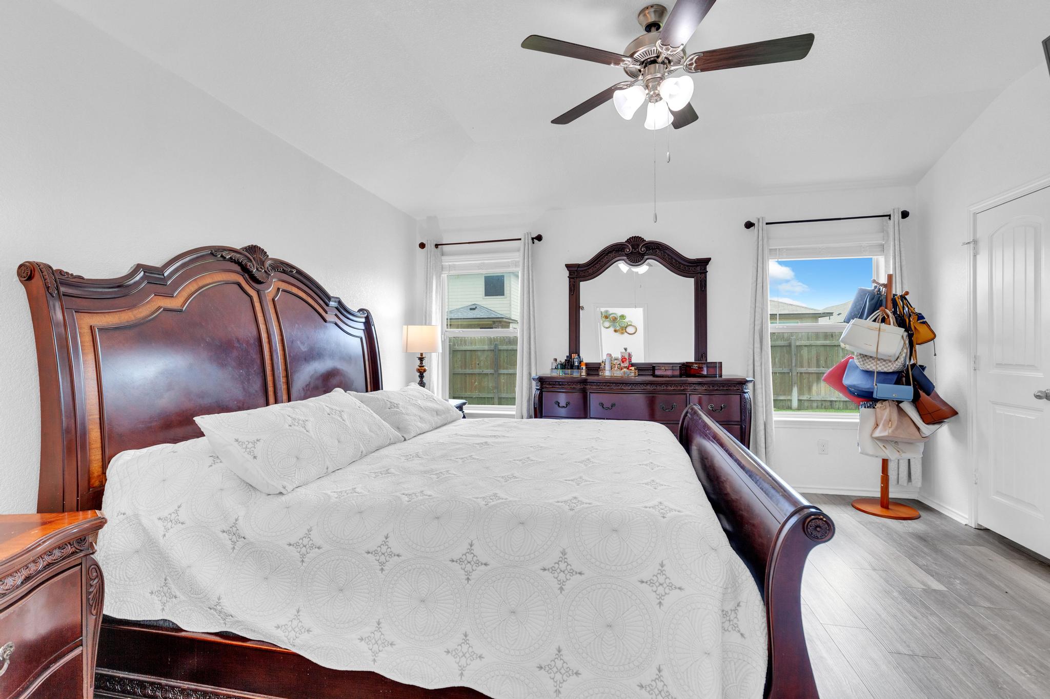 119 Beth Ann Loop Taylor, TX 76574 - Photo 24 of 31 Hardwood-style flooring and multiple windows create a peaceful and airy bedroom retreat.