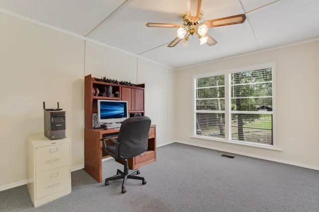 a view of a workspace with furniture and a window