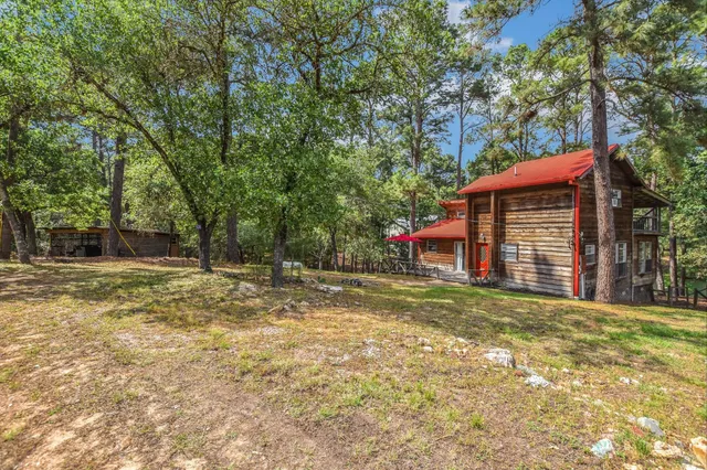 a view of a house with backyard and trees