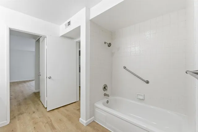 a white bath tub sitting next to a shower