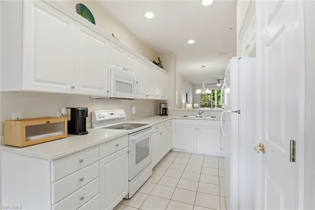 a kitchen with white cabinets and appliances