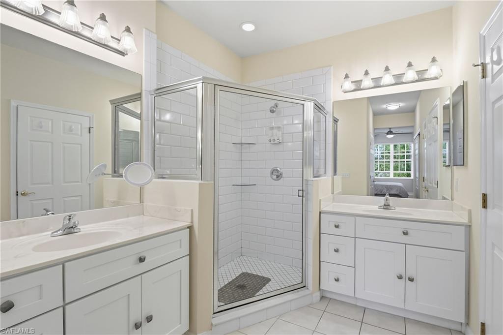 4873 Hampshire Court, Unit 104 Naples, FL 34112 - Photo 20 of 43 a bathroom with a shower sink double and mirror