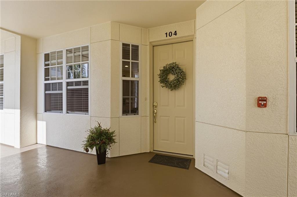 4873 Hampshire Court, Unit 104 Naples, FL 34112 - Photo 2 of 43 an entryway with wooden floor and windows