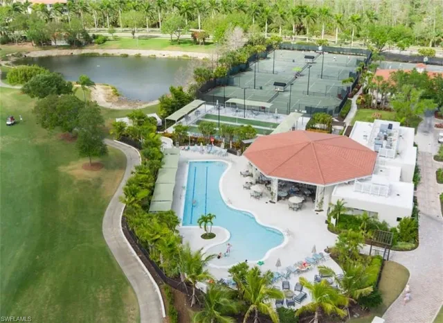 an aerial view of a swimming pool with outdoor seating and yard