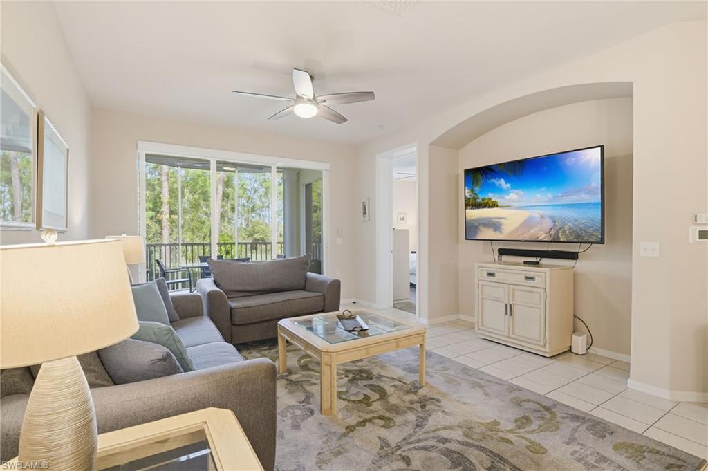 4873 Hampshire Court, Unit 104 Naples, FL 34112 - Photo 5 of 43 a living room with furniture and a flat screen tv