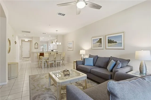 a living room with furniture and a view of kitchen