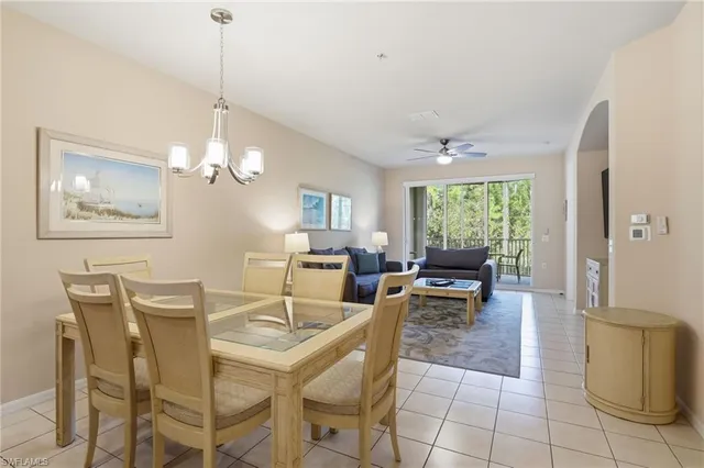 a view of a dining room with furniture a chandelier and large windows