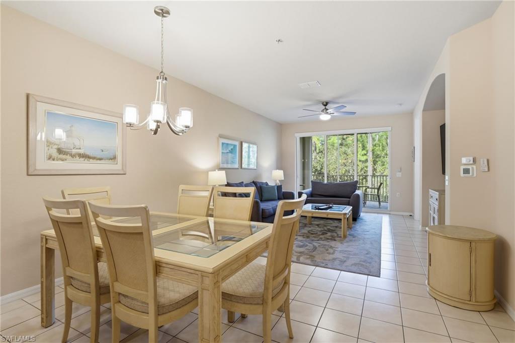 4873 Hampshire Court, Unit 104 Naples, FL 34112 - Photo 8 of 43 a view of a dining room with furniture a chandelier and large windows