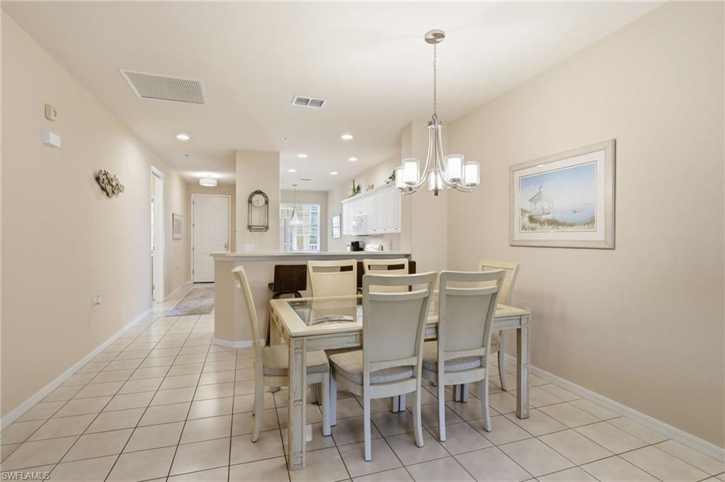 4873 Hampshire Court, Unit 104 Naples, FL 34112 - Photo 9 of 43 a view of a dining room with furniture and chandelier